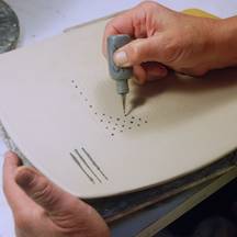 Nan's hands inlaying slip into a plate